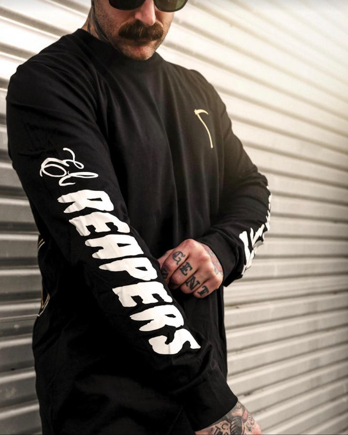 Black custom printed t-shirt held up against a roller door