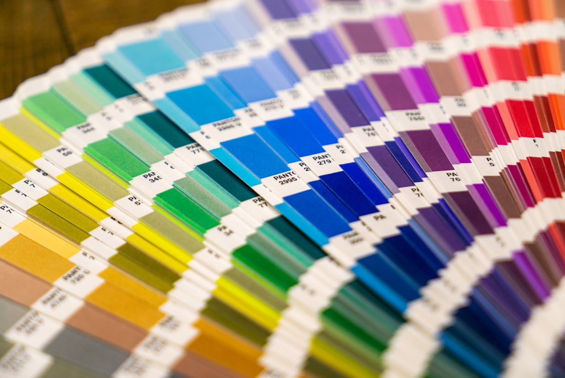 A fanned Pantone colour swatch book showing a full spectrum of ink colours for colour matching.